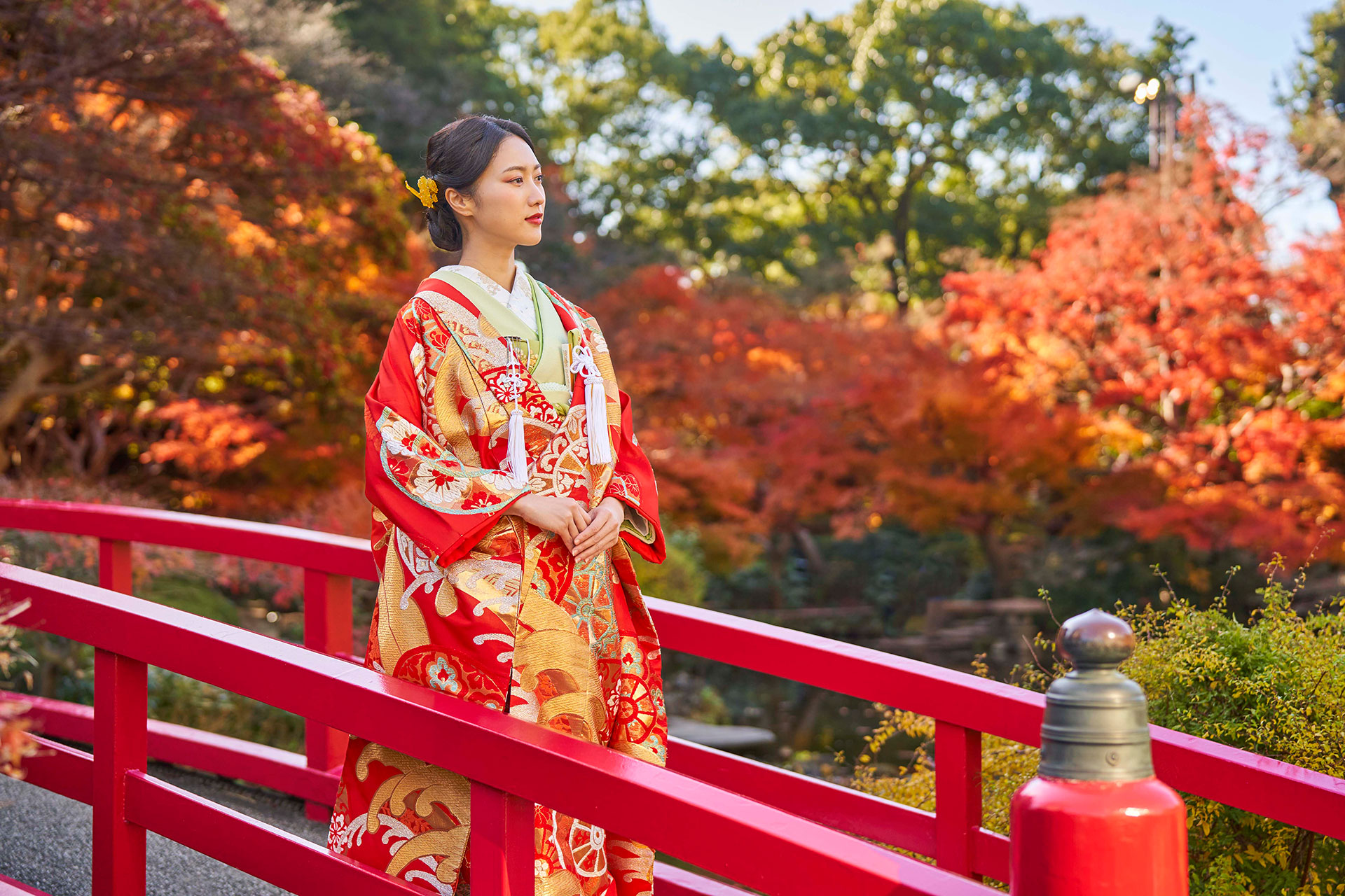 日本庭園の太鼓橋に立つ和装の新婦の様子